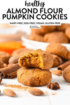 healthy almond floured pumpkin cookies stacked on top of each other with cinnamons around them