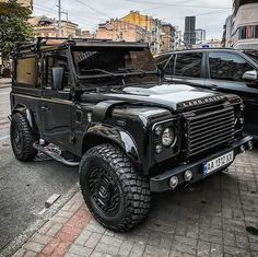 a black land rover is parked on the street