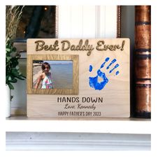 a wooden frame with a hand and foot print on it