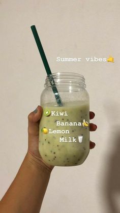 a hand holding a glass with a green smoothie in it and the words kiwi banana lemon milk