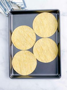 four tortillas on a baking sheet ready to go into the oven for dinner