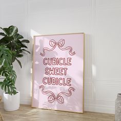 a pink poster with the words cuddle sheet cubicle on it next to a potted plant