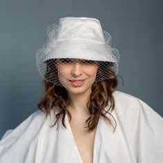 Our ultra-femme bucket hat is made of ivory satin (100% cotton). It is decoratet with french veiling. It is very elegant, a little bit crazy and fashionable. It has also small round pedant with logo boZka. Size 55-58cm RETURNS AND EXCHANGE DETAIL Returns must be made within 14 days (date on the post mark is important). RETURNS FROM OUTSIDE EUROPEN UNION - we accept but they are not fully refounded. Please note that shipping fees are not refundable. We also LEAVE APPROXIMATELY 25-30% FEE - it is Tulle Hat For Weddings And Kentucky Derby, Elegant White Bucket Hat, White Brimmed Cloche Hat For Wedding, White Short Brim Cloche Hat For Weddings, White Cloche Hat With Short Brim For Wedding, White Summer Wedding Veil, Summer Wedding Bucket Hat, Elegant Summer Tulle Hats, Chic Brimmed Cloche Hat For Wedding