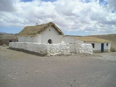 an old white church with a thatched roof