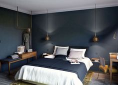 a bedroom with dark blue walls and white bedding