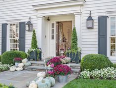 the front door is decorated with flowers and pumpkins