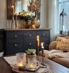 candles are lit on a tray in front of a couch