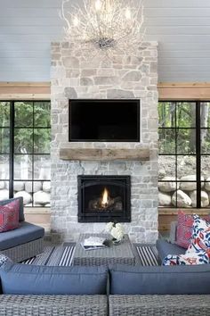 a living room filled with furniture and a flat screen tv mounted on the wall above a fire place