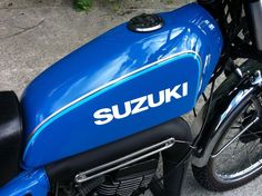 the suzuki motorcycle is parked on the concrete