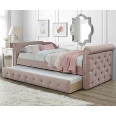 a pink daybed sitting on top of a wooden floor next to a white rug