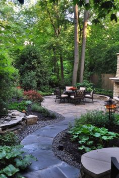 A serene garden with a stone patio, outdoor dining set, and surrounded by lush greenery and tall trees. Modern Outdoor Living Area, Diy Backyard Projects, Simple Diy Projects, Cozy Garden, Modern Outdoor Living, Garden Retreat