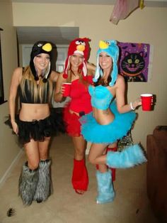 three women dressed up in costumes posing for the camera with one holding a coffee cup