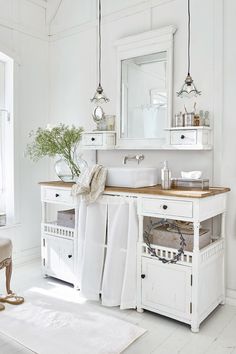 a white bathroom with two sinks and mirrors