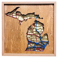 a wooden frame with a cut out map of the state of michigan in blue and red