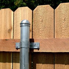 a wooden fence with a metal pole attached to it