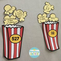 two red and white striped paper popcorns with numbers on the top one is 527