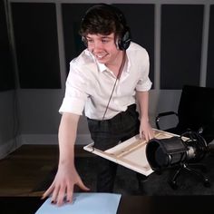 a young man wearing headphones and holding a tray with something in front of him