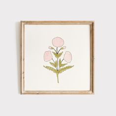 a painting with pink flowers in a wooden frame on a white wall next to a plant