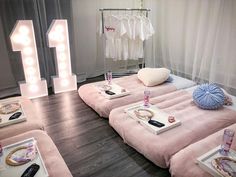 a room with pink couches and lights on the wall, in front of a white curtain