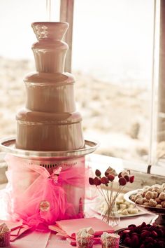 a large chocolate cake sitting on top of a table next to other desserts and candies