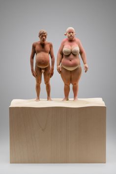 two figurines standing on top of a wooden block