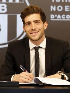 a man sitting at a desk with a pen and paper