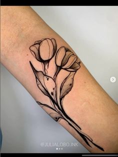 a black and white flower tattoo on the arm