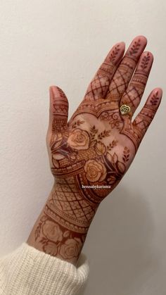 a woman's hand with henna tattoos on it