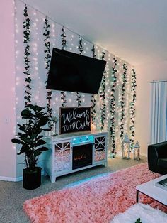 a living room with christmas lights on the wall and a flat screen tv above it