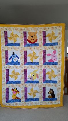 a winnie the pooh quilt hanging on a wall