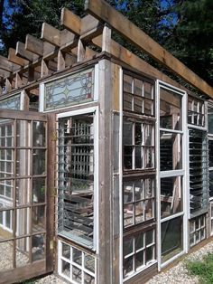 an old wooden building with many windows and bars on the outside, in front of some trees