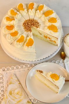 there is a white cake with orange slices on the plate and another piece has been cut from it