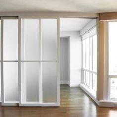 an empty room with sliding glass doors and hard wood flooring