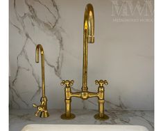 a white sink sitting next to a gold faucet