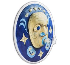 a blue and white plate with a face painted on it's side, in the shape of a moon