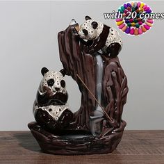 two panda bears sitting on top of a waterfall