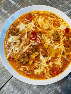 a bowl of lasagna soup on a wooden table with the words lasagna soup above it