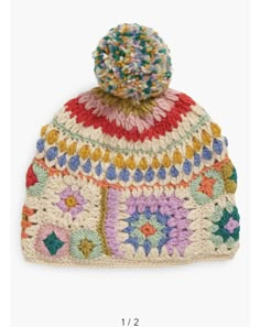 a multicolored crocheted hat with a pom - pom