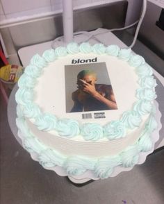 a white cake with blue frosting and a photo on it