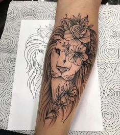 a woman's leg with a lion and flowers on it, in black and white