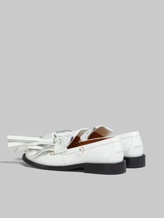 Bambi loafer crafted from brushed calfskin leather. Classic beefroll construction with saddle strap. Updated with an oversized fringe folded over the toe and maxi tassels. Embellished with metal piercing details along the edge. Leather insole and leather sole. White Leather Loafers With Tassels, Luxury Leather Loafers With Tassels, Classic Leather Tassel Loafers With Fringe, Leather Tassel Loafers With Fringe For Work, Elegant Fringe Tassel Loafers For Formal Occasions, Elegant Formal Tassel Loafers With Fringe, Metal Piercing, Fuzzy Wuzzy, Heel Accessories