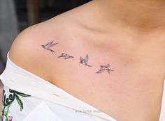 a woman's chest with three birds on the left side of her body and one bird in the middle