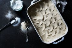 a pan filled with ice cream next to two spoons