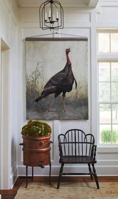 two chairs and a painting hanging on the wall in a room with a potted plant