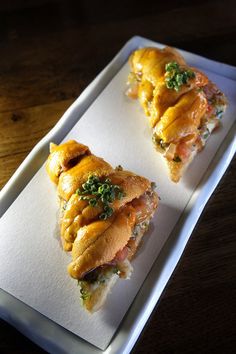 two pieces of food sitting on top of a white tray