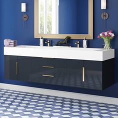 a bathroom with blue walls and a white sink under a large mirror on the wall