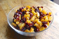 a glass bowl filled with fruit on top of a wooden table