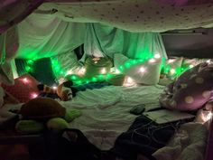 a bed with green lights and stuffed animals on it