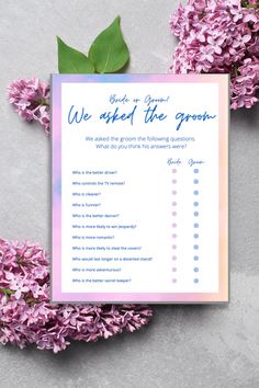 a pink and blue wedding checklist with lila flowers on the table next to it