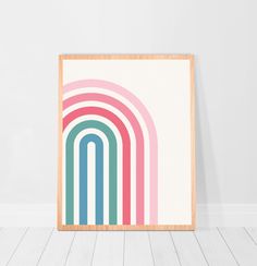 an art print with multicolored lines on the wall in front of a wooden frame